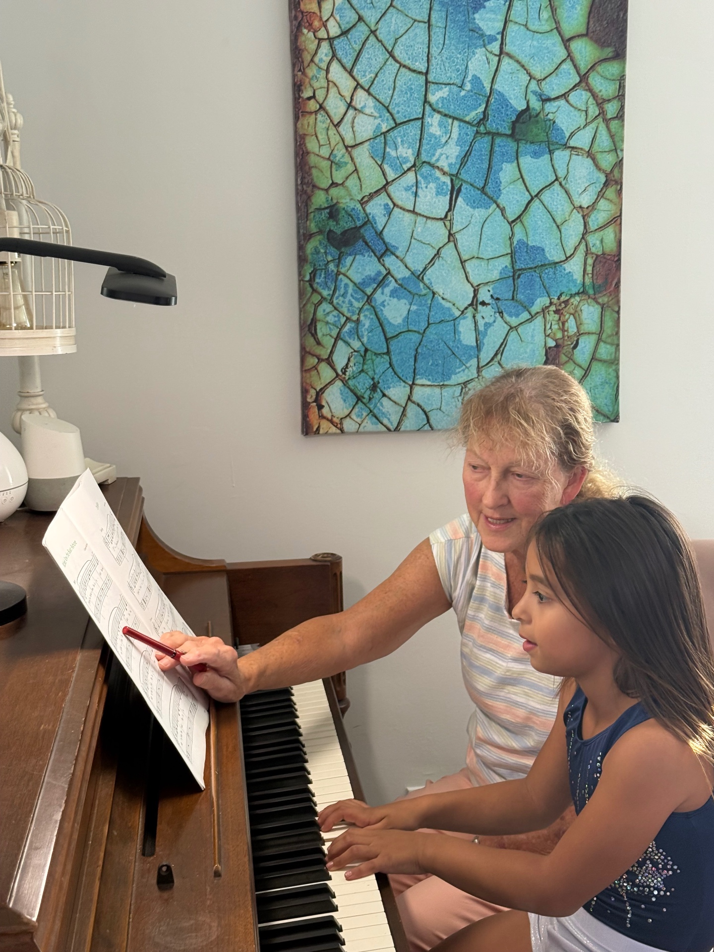 Bonnie Ziervogel pointing to sheet music while teaching music theory to a piano student