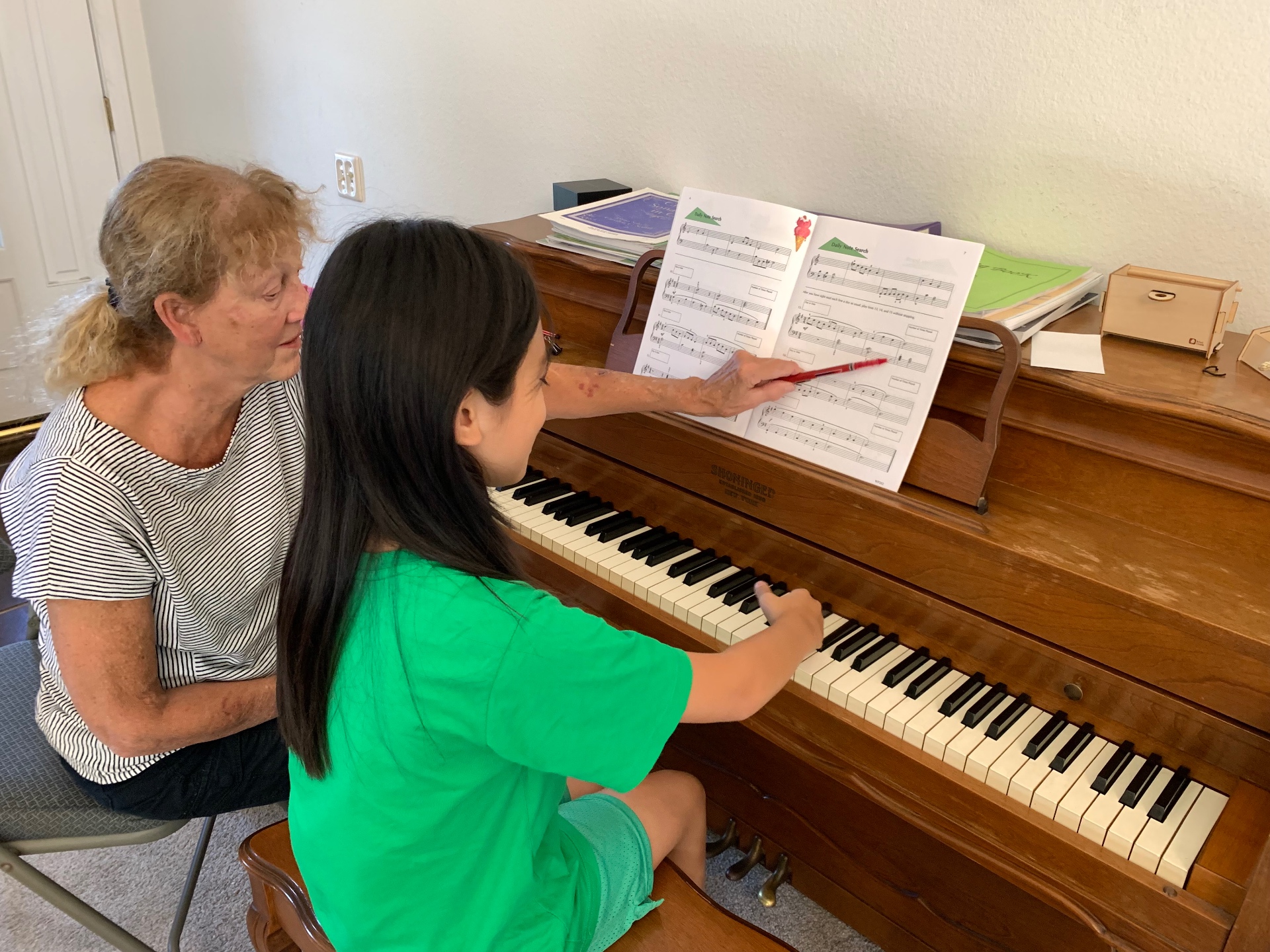 Young piano student practicing scales at the piano during an in-home lesson